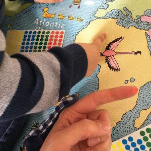 Children placing stickers on a map of the world