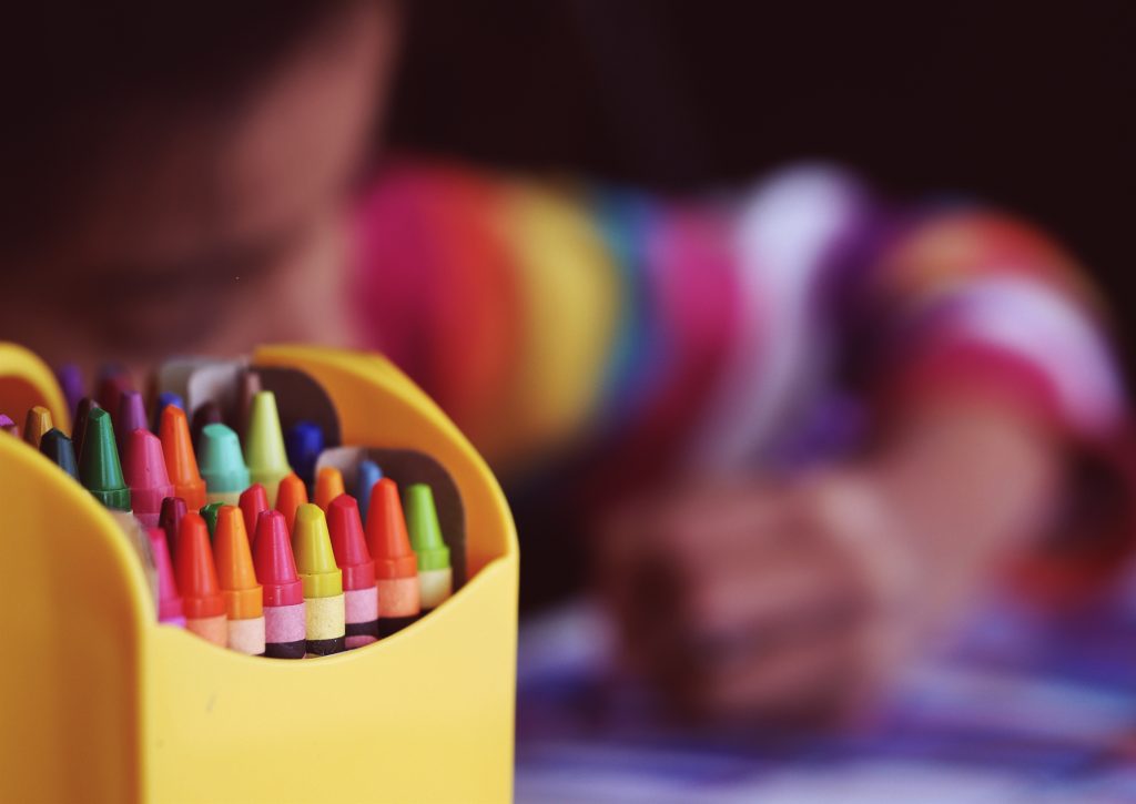 child colouring with crayons