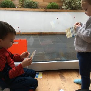 children making pictures with stickers on a window